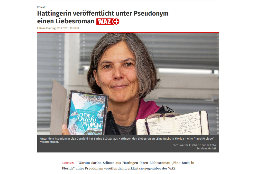 Eine weibliche Person mit kinnlangen Haaren hält lächelend ein E-Book mit dem Titel Eine Bucht in Florida in der einen und einem Notizbuch in der anderen Hand in die Kamera.